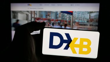 Stuttgart, Almanya - 06-18-2025: BAE havaalanı yetkilisi Dubai Havaalanı Şirketi 'nin logosunun bulunduğu cep telefonu sahibi kişi web sitesinin önünde ekranda. Telefon ekranına odaklan.