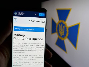 Stuttgart, Almanya - 06-18-2025: Güvenlik servisi Sluzhba Bezpeky Ukrayna SBU 'nun web sayfası olan akıllı telefonu logonun önünde tutan kişi. Telefon ekranının merkezine odaklan.