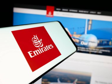 Stuttgart, Almanya - 06-18-2025: İnternet sitesinin önünde ekranda BAE havayolu şirketi Emirates 'in logosu bulunan akıllı telefon. Telefon ekranının merkez sağına odaklan.