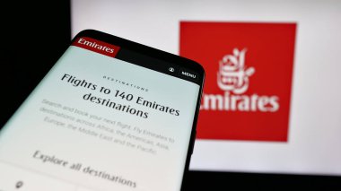 Stuttgart, Almanya - 06-18-2025: UAE havayolu şirketi Emirates 'in web sitesiyle birlikte cep telefonu logonun önünde ekranda. Telefon ekranının sol üst kısmına odaklan.