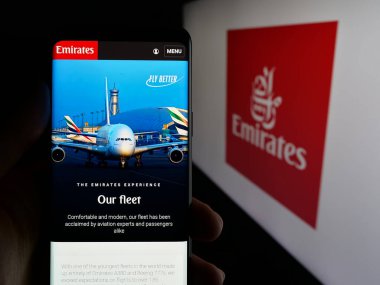 Stuttgart, Almanya - 06-18-2025: UAE havayolu şirketi Emirates 'in web sayfası ile akıllı telefon taşıyan kişi logonun önünde ekranda. Telefon ekranının merkezine odaklan.