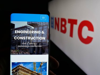 Stuttgart, Almanya - 06-18-2025: Kuveyt müteahhitlik şirketi NBTC Group 'un internet sayfası olan cep telefonu logosu önünde ekranda. Telefon ekranının merkezine odaklan.