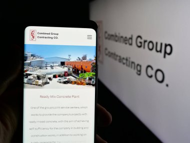 Stuttgart, Almanya - 06-18-2025: Combined Group Contracting Company 'nin (CGC) web sayfası ile akıllı telefonu olan kişi logonun önünde ekranda. Telefon ekranının merkezine odaklan.