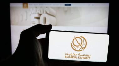 Stuttgart, Almanya - 06-19-2025: Borsa Borsası logosu olan cep telefonu sahibi kişi Boursa Kuveyt Güvenlik Şirketi web sayfasının önünde ekranda. Telefon ekranına odaklan.