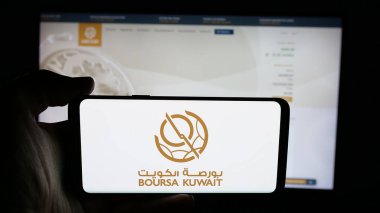 Stuttgart, Almanya - 06-19-2025: Stok borsası logosu olan cep telefonu sahibi Boursa Kuveyt Güvenlik Şirketi web sayfasının önünde ekranda. Telefon ekranına odaklan.