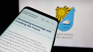 Stuttgart, Almanya - 06-19-2025: Eğitim kurumu Kuveyt Üniversitesi 'nin web sitesinin bulunduğu cep telefonu logonun önünde ekranda. Telefon ekranının sol üst kısmına odaklan.