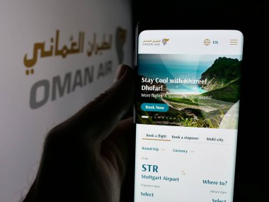 Stuttgart, Almanya - 06-20-2025: Havayolu şirketi Umman Air 'in web sayfası olan cep telefonu logonun önünde ekranda. Telefon ekranının merkezine odaklan.
