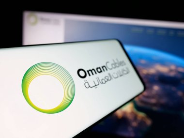 Stuttgart, Almanya - 06-20-2025: İnternet sitesi önünde ekranda Umman Kablo Endüstrisi logosu bulunan akıllı telefon. Telefon ekranının soluna odaklan.