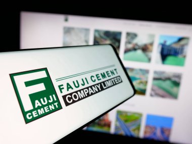 Stuttgart, Almanya - 06-20-2025: Pakistanlı firma Fauji Çimento Şirketi 'nin logosuna sahip akıllı telefon web sitesinin önünde ekranda. Telefon ekranının merkez soluna odaklan.