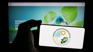 Stuttgart, Almanya - 06-20-2025: Tarım projesi Yeşil Pakistan Girişimi logosu olan cep telefonu web sayfası önünde ekranda. Telefon ekranına odaklan.
