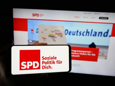 Stuttgart, Almanya - 06-25-2025: İnternet sitesinin önünde Sozialdemokratische Partei Deutschlands (SPD) logosunun bulunduğu akıllı telefonu elinde tutan kişi. Telefon ekranına odaklan.