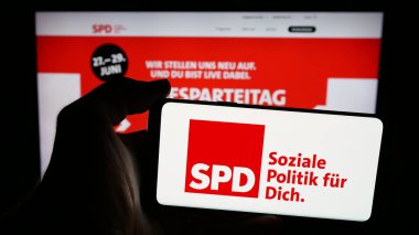 Stuttgart, Almanya - 06-25-2025: İnternet sayfasının önünde Sozialdemokratische Partei Deutschlands (SPD) logosunun bulunduğu cep telefonu sahibi kişi. Telefon ekranına odaklan.