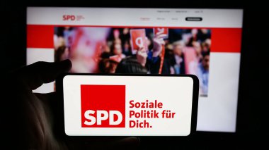 Stuttgart, Almanya - 06-25-2025: İnternet sayfası önünde Sozialdemokratische Partei Deutschlands (SPD) logosunun bulunduğu cep telefonu sahibi kişi. Telefon ekranına odaklan.