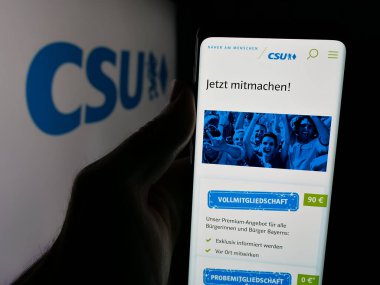 Stuttgart, Almanya - 06-25-2025: Bayern Olay Yeri İnceleme Birimi 'nde parti Christlich-Soziale Union web sitesi ile akıllı telefon sahibi kişi logonun önünde ekranda. Telefon ekranının merkezine odaklan.