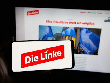 Stuttgart, Almanya - 06-25-2025: Alman sosyalist partisi Die Linke 'ın logosunu taşıyan kişi web sitesinin önünde ekranda. Telefon ekranına odaklan.