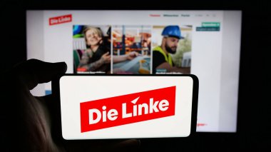 Stuttgart, Almanya - 06-25-2025: Alman sosyalist partisi Die Linke 'ın logosunun bulunduğu cep telefonu web sayfası önünde ekranda. Telefon ekranına odaklan.