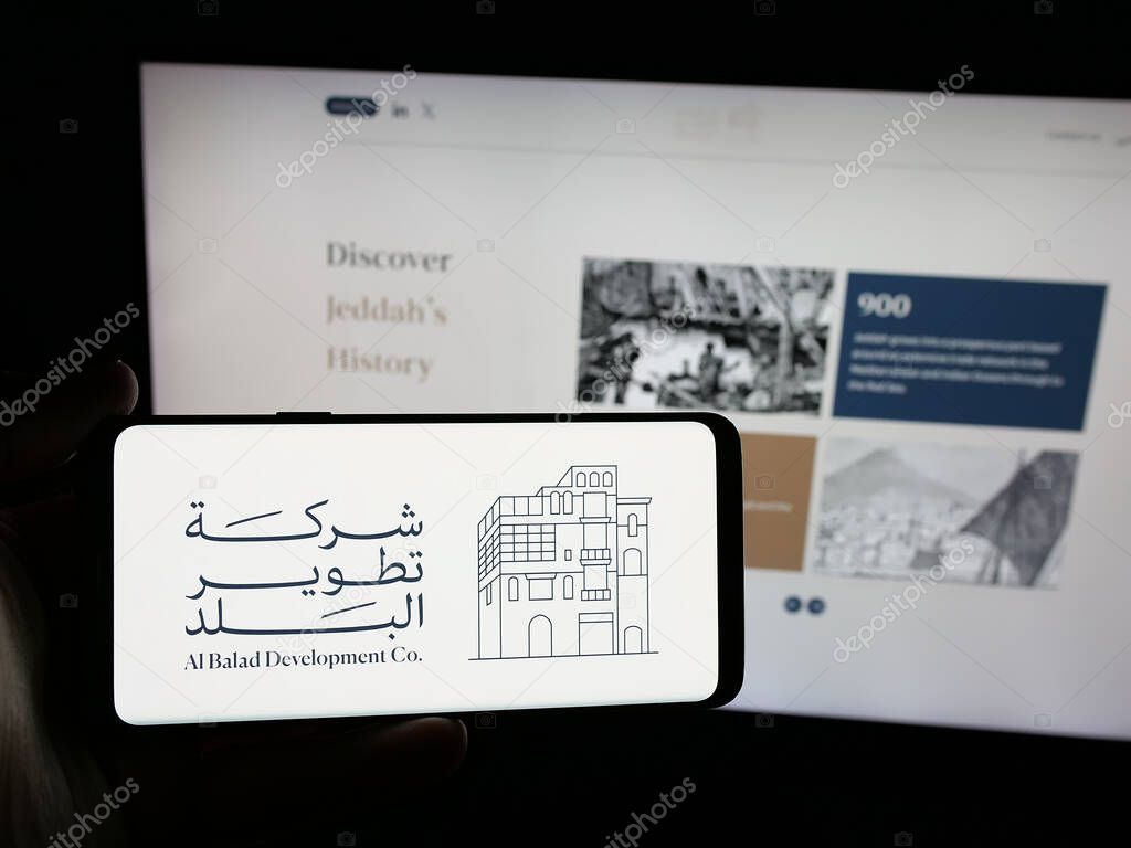 Stuttgart, Germany - 06-14-2025: Person holding smartphone with logo of business Al Balad Development Company (BDC) on screen in front of website. Focus on phone display.