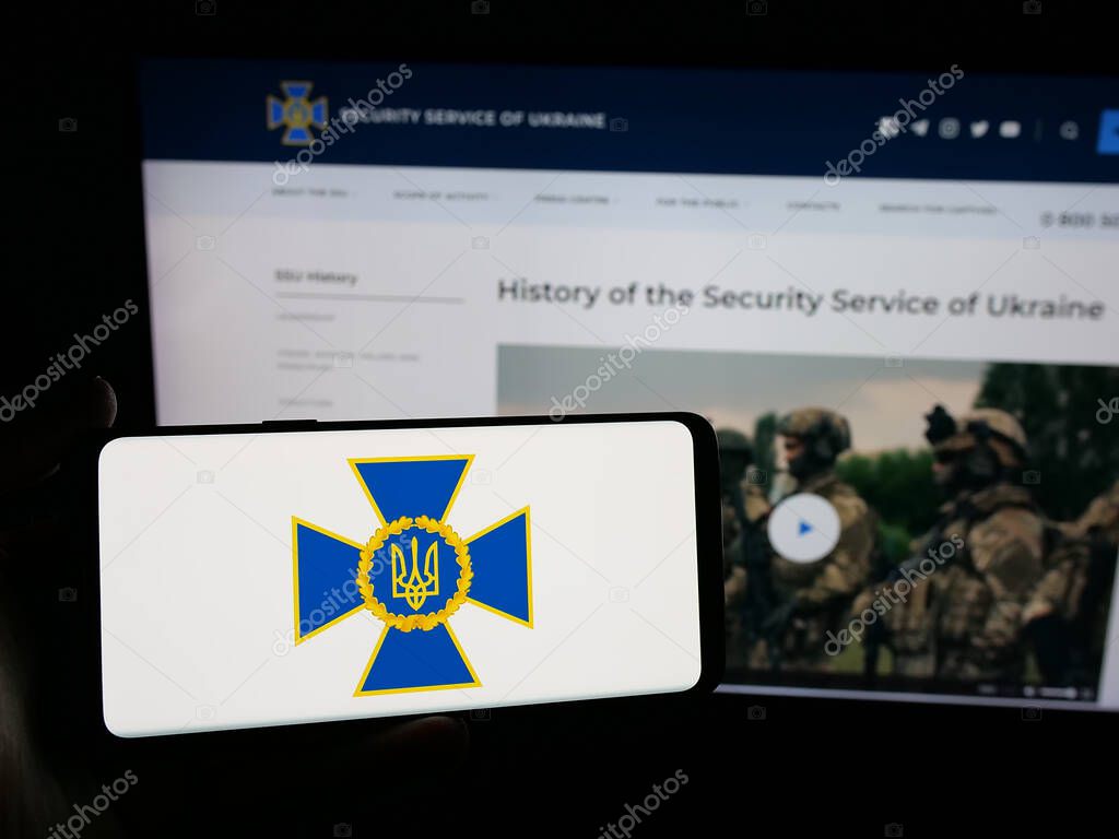 Stuttgart, Germany - 06-18-2025: Person holding smartphone with logo of security service Sluzhba Bezpeky Ukrainy SBU on screen in front of website. Focus on phone display.