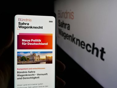Stuttgart, Almanya - 06-26-2025: Alman partisi Buendnis Sahra Wagenknecht 'in (BSW) web sayfası logonun önünde duran kişi. Telefon ekranının merkezine odaklan.
