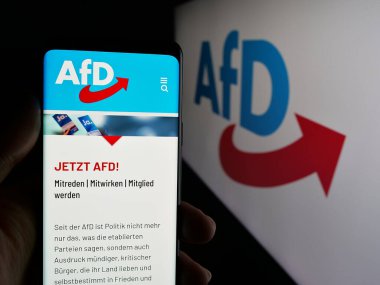 Stuttgart, Almanya - 06-26-2025: Logonun önünde Alman Alternatif fuer Deutschland (AfD) web sayfası bulunan kişi. Telefon ekranının merkezine odaklan.