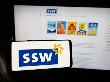 Stuttgart, Almanya - 06-26-2025: İnternet sitesinin önünde üzerinde Alman Suedschleswigscher Waehlerverband (SSW) logosu bulunan kişi. Telefon ekranına odaklan.
