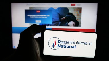 Stuttgart, Almanya - 06-26-2025: Fransız partisi Rassemblement National (RN) logosuna sahip cep telefonu web sayfası önünde ekranda. Telefon ekranına odaklan.