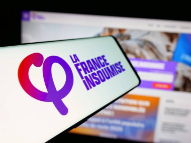 Stuttgart, Almanya - 06-26-2025: İnternet sitesinin önünde Fransız partisi La France Insoumise 'in (FI) logosuna sahip akıllı telefon. Telefon ekranının soluna odaklan.