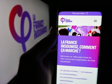 Stuttgart, Almanya - 06-26-2025: Fransız partisi La France Insoumise 'in (FI) web sayfası logo önünde bulunan kişi. Telefon ekranının merkezine odaklan.