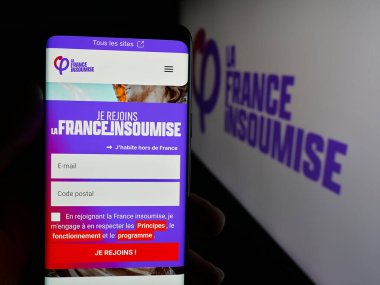 Stuttgart, Almanya - 06-26-2025: Fransız partisi La France Insoumise 'in (FI) web sayfası logonun önünde duran kişi. Telefon ekranının merkezine odaklan.