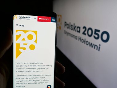 Stuttgart, Almanya - 06-27-2025: Polska 2050 Szymona Holowni (PL2050) adlı partinin web sayfası logonun önünde duran kişi. Telefon ekranının merkezine odaklan.