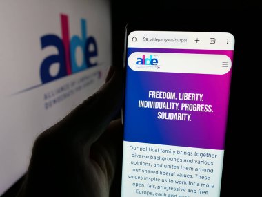 Stuttgart, Almanya - 06-27-2025: Avrupalı liberaller ve demokratlar partisi ALDE 'nin web sayfasını elinde tutan kişi logonun önünde ekranda. Telefon ekranının merkezine odaklan.