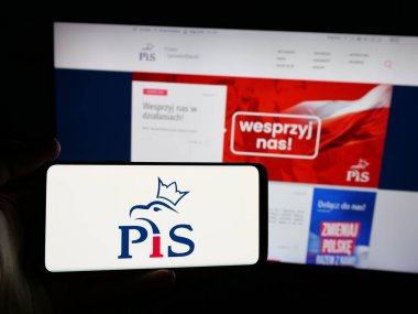 Stuttgart, Almanya - 06-27-2025: Polonya partisi Prawo i Sprawiedliwosc 'un (PiS) logosuna sahip kişi web sitesinin önünde ekranda. Telefon ekranına odaklan.