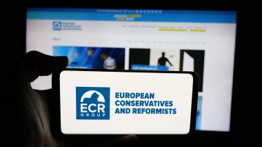 Stuttgart, Almanya - 07-07-2025: İnternet sayfası önünde Avrupalı Muhafazakârlar ve Reformcuların (AİHM) logosunu elinde tutan kişi. Telefon ekranına odaklan.