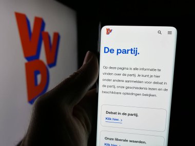 Stuttgart, Almanya - 07-09-2025: Volkspartij voor Vrijheid en Democratie 'nin (VVVD) web sayfası logonun önünde duran kişi. Telefon ekranının merkezine odaklan.