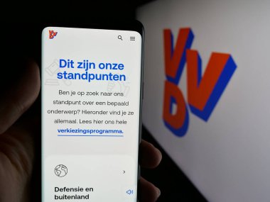 Stuttgart, Almanya - 07-09-2025: Volkspartij voor Vrijheid en Democratie 'nin (VVVD) web sayfası logonun önünde bulunan kişi. Telefon ekranının merkezine odaklan.