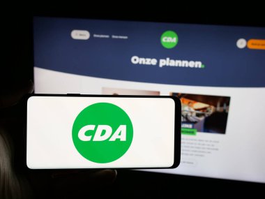 Stuttgart, Almanya - 07-09-2025: Hollandalı parti Christen-Democratisch Appel 'in (CDA) logosunu taşıyan kişi web sitesinin önünde ekranda. Telefon ekranına odaklan.
