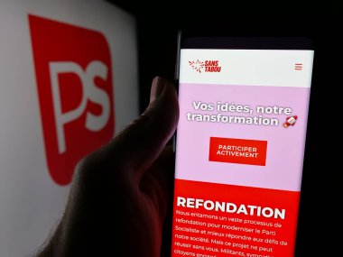 Stuttgart, Almanya - 07-10-2025: Belçika siyasi partisi Parti Socialiste 'nin (PS) web sitesi ile akıllı telefonu logo önünde tutan kişi. Telefon ekranının merkezine odaklan.