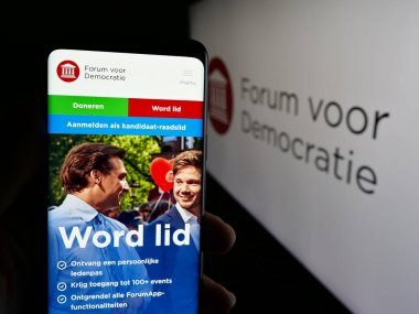 Stuttgart, Almanya - 07-10-2025: Hollandalı parti Forum voor Democratie 'nin (FvD) web sitesi logonun önünde cep telefonu tutan kişi. Telefon ekranının merkezine odaklan.
