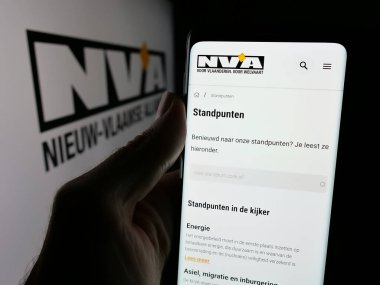Stuttgart, Almanya - 07-10-2025: Belçika partisi Nieuw-Vlaamse Alliantie 'nin (N-VA) web sayfası logonun önünde duran kişi. Telefon ekranının merkezine odaklan.