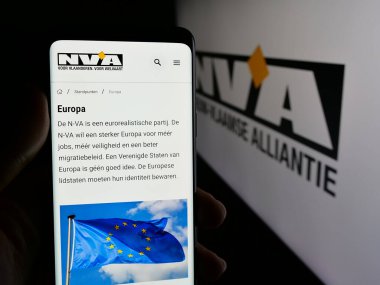 Stuttgart, Almanya - 07-10-2025: Belçika partisi Nieuw-Vlaamse Alliantie 'nin (N-VA) web sayfası logonun önünde duran kişi. Telefon ekranının merkezine odaklan.