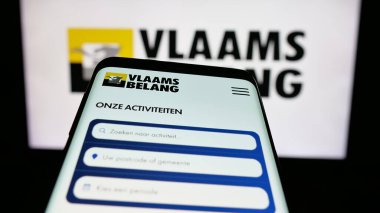 Stuttgart, Almanya - 07-10-2025: Belçikalı siyasi parti Vlaams Belang 'ın (VB) web sitesinin bulunduğu cep telefonu logonun önünde ekranda. Telefon ekranının sol üst kısmına odaklan.