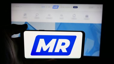 Stuttgart, Almanya - 07-10-2025: İnternet sayfası önünde Belçika partisi Mouvement Reformatör 'ün (MR) logosunu elinde tutan kişi. Telefon ekranına odaklan.