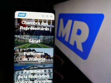 Stuttgart, Almanya - 07-10-2025: Belçika partisi Mouvement Reformatör 'ün (MR) web sayfası logonun önünde duran kişi. Telefon ekranının merkezine odaklan.