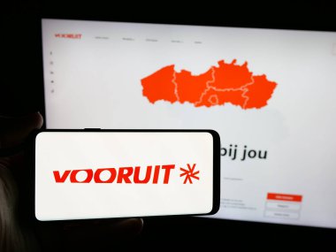 Stuttgart, Almanya - 07-10-2025: Flaman siyasi partisi Vooruit 'in logosunu web sitesinin önünde elinde tutan kişi. Telefon ekranına odaklan.