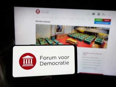Stuttgart, Almanya - 07-10-2025: Hollandalı parti Forum Voor Democratie 'nin (FVD) logosunu elinde tutan kişi web sitesinin önünde ekranda. Telefon ekranına odaklan.