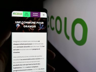 Stuttgart, Almanya - 07-11-2025: Belçika 'nın siyasi partisi Ecolo' nun web sitesinin logosu önünde akıllı telefon tutan kişi. Telefon ekranının merkezine odaklan.
