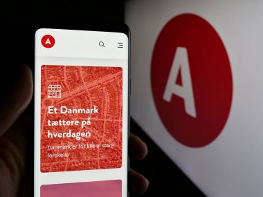 Stuttgart, Almanya - 07-11-2025: Danimarka siyasi partisi Socialdemokraterne 'in (S) web sitesi logonun önünde cep telefonu tutan kişi. Telefon ekranının merkezine odaklan.