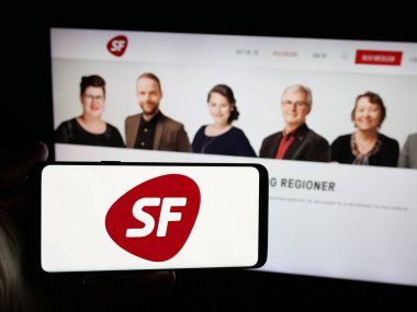 Stuttgart, Almanya - 07-11-2025: İnternet sitesi önünde üzerinde Danimarka partisi Socialistisk Folkeparti (SF) logosu bulunan akıllı telefon sahibi kişi. Telefon ekranına odaklan.