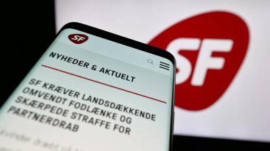 Stuttgart, Almanya - 07-11-2025: Danimarka partisi Socialistisk Folkeparti 'nin (SF) web sitesinin bulunduğu cep telefonu logonun önünde ekranda. Telefon ekranının sol üst kısmına odaklan.