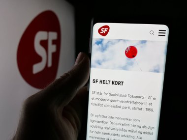 Stuttgart, Almanya - 07-11-2025: Danish Party Socialistisk Folkeparti 'nin (SF) web sayfası logonun önünde duran kişi. Telefon ekranının merkezine odaklan.